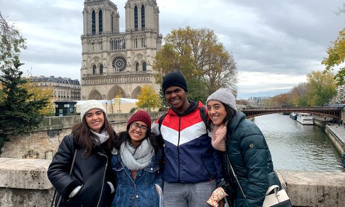 Students standing in front of Notre Dame de Paris.