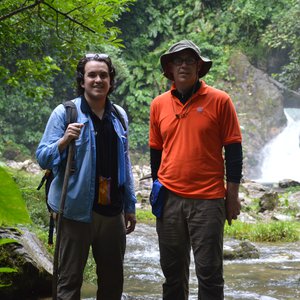 Nicolas Pérez-Consuegra and professor Gregory Hoke standing in front of a waterfall in the Caqueta Canyon.