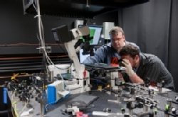 Martin Forstner (left) works with graduate student Ian McCabe on laser-powered microscope.