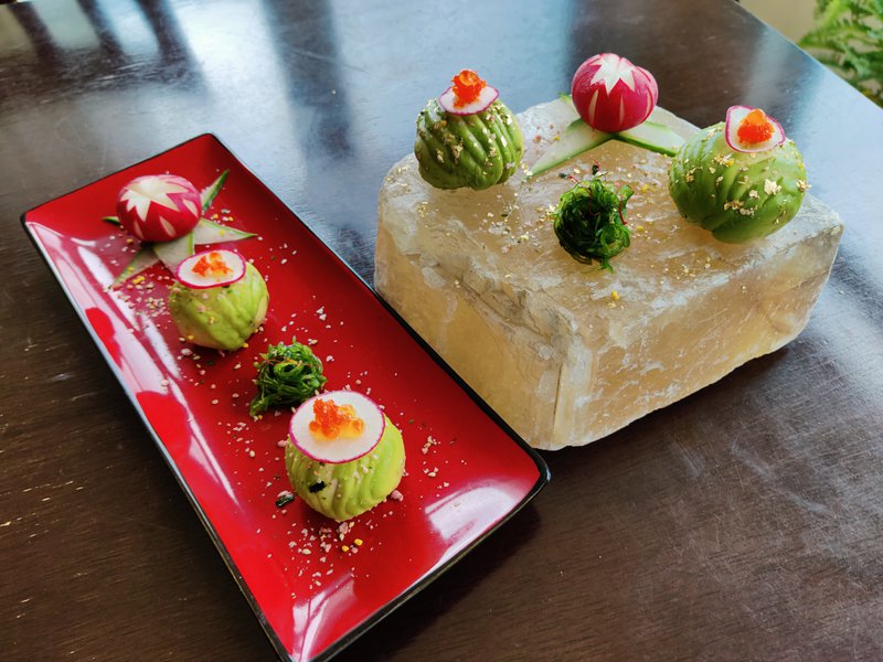seaweed salad and avocado sushi balls on a piece of calcite