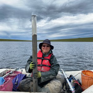 Melissa Chipman holding a freshly extracted sediment core from an Alaskan Lake.