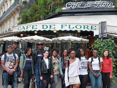Students pose in front of the famous Café de Flore as part of Paris Noir 2016
