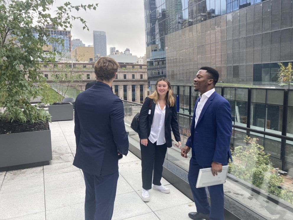 Students chat with Michael Oviosu ’16 (right) on the rooftop of EY during the Stocks and Finance Immersion.
