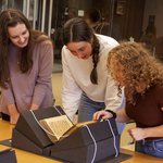 Students examine a book