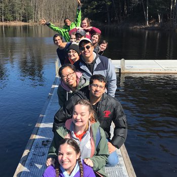 Students standing in a line on a dock.