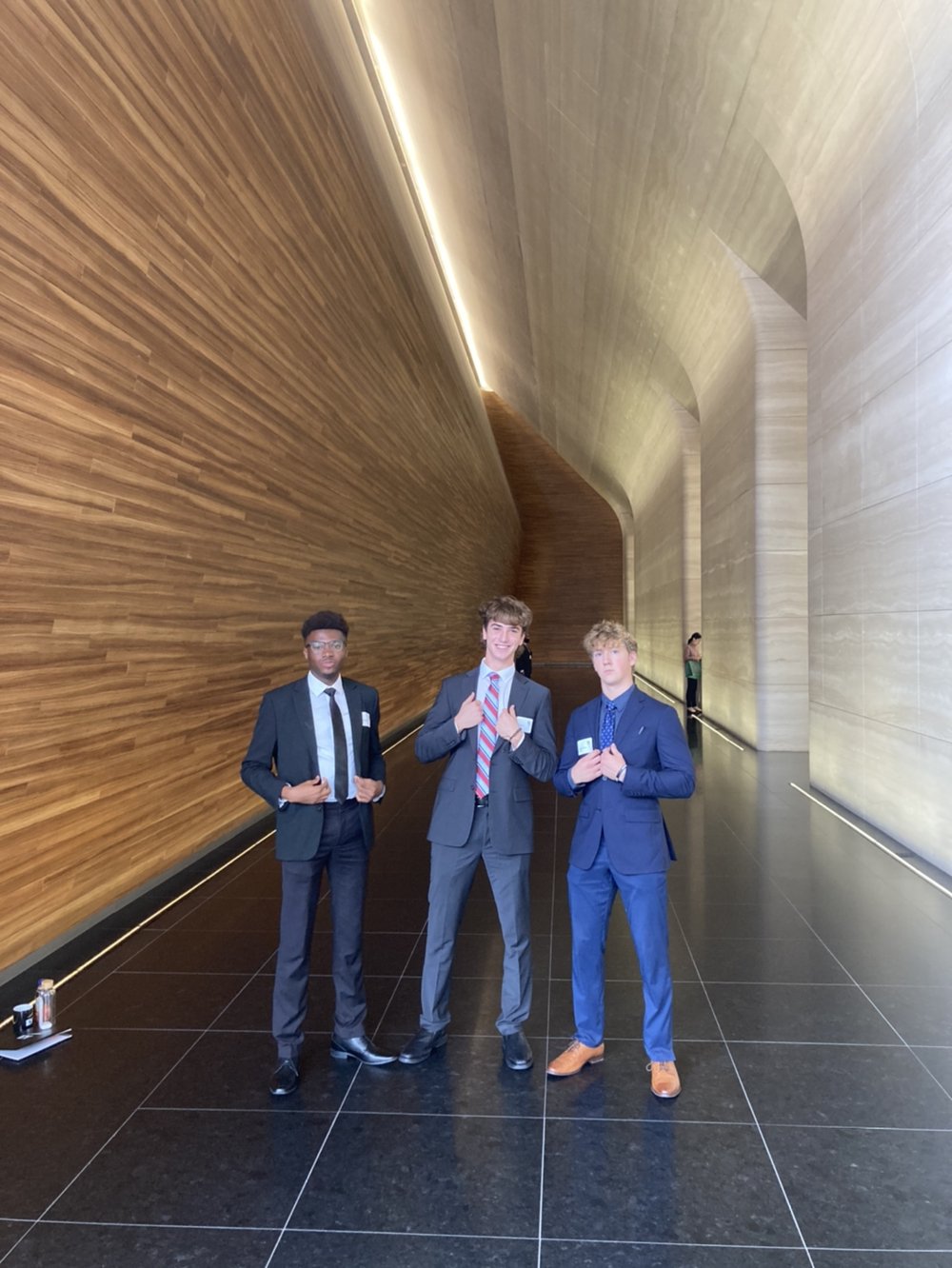 From left to right, Uzochi Onyenkpa, Noah Marotta, and Will Moroney pose for a photo in the hallway of EY.