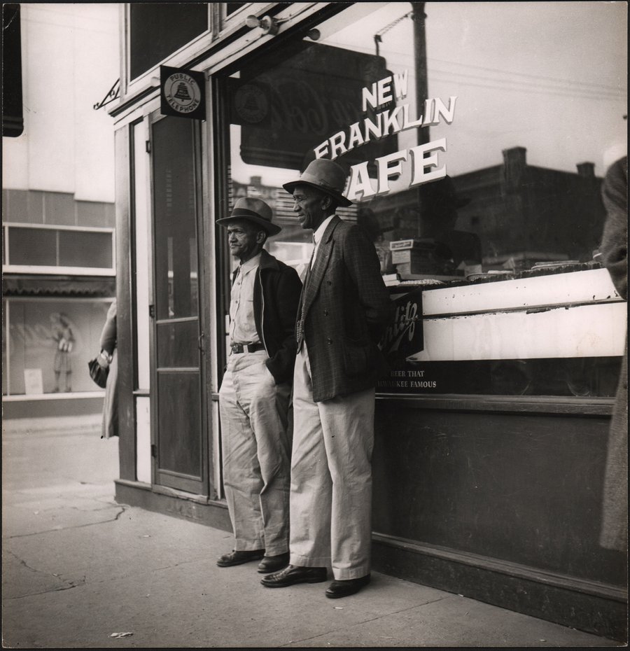 Two black men outside a cafe.