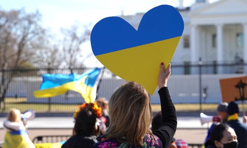 A demonstrator in Washington, D.C. holding a heart painted with the colors of the Ukrainian national flag.