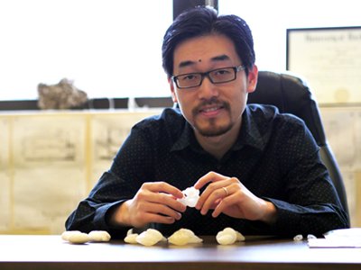 Zunli Lu holding expanded replicas of fossils