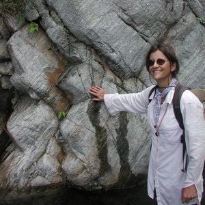 Suzanne Baldwin examining a gneiss rock in Papua New Guinea.